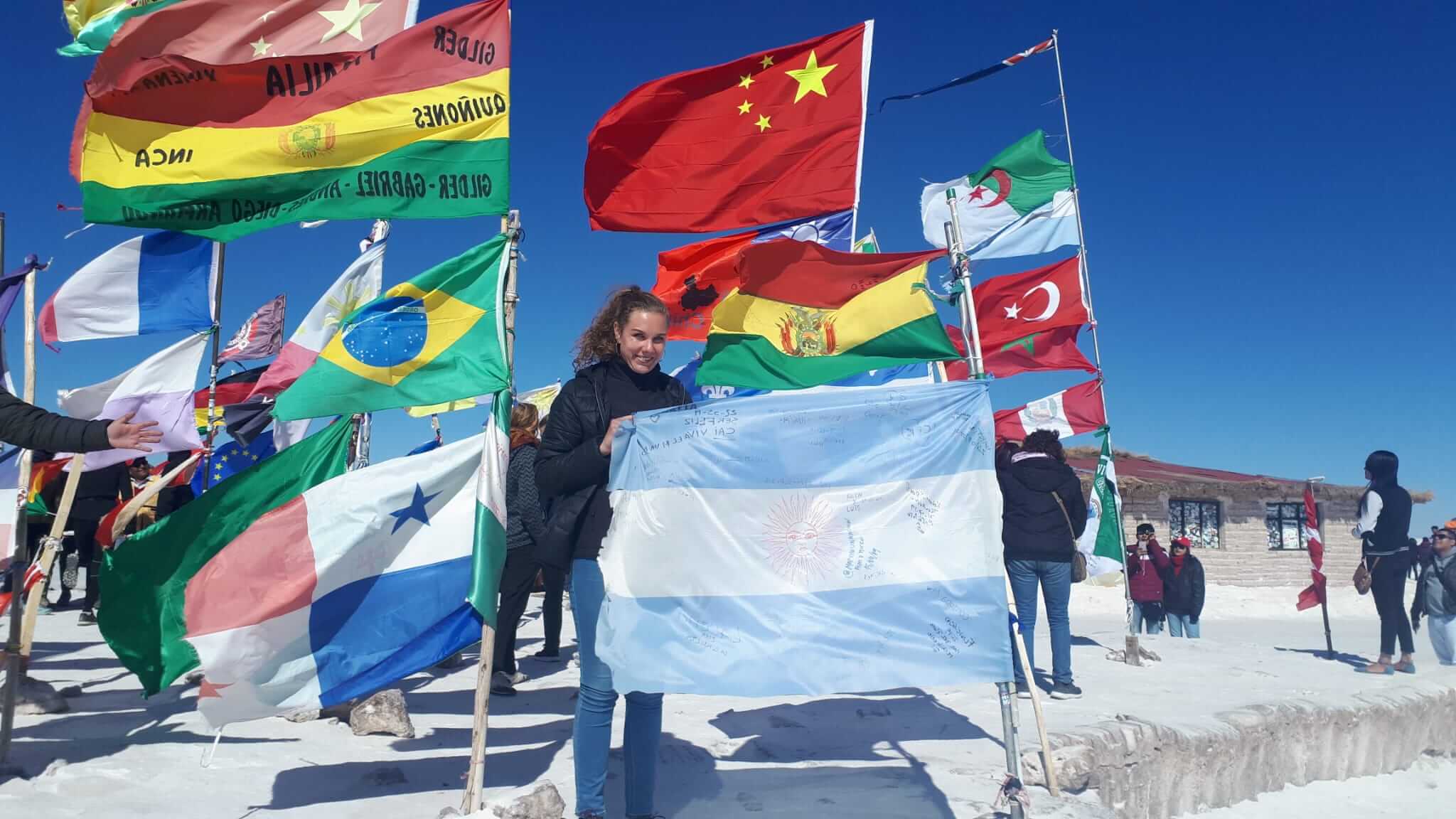 Barbara Brandmüller auf einem Berggipfel mit Flaggen